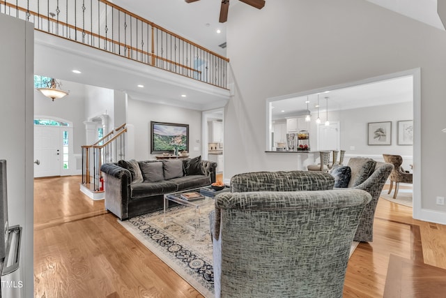 3007 Krogen Ct, Creedmoor, NC 27522 - living room with a towering ceiling, ceiling fan, light wood-style floors, stairs, and baseboards