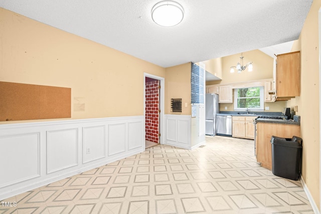 3 Cobble Glen Ct, Durham, NC 27713 - kitchen featuring appliances with stainless steel finishes, a sink, wainscoting, a chandelier, and light floors