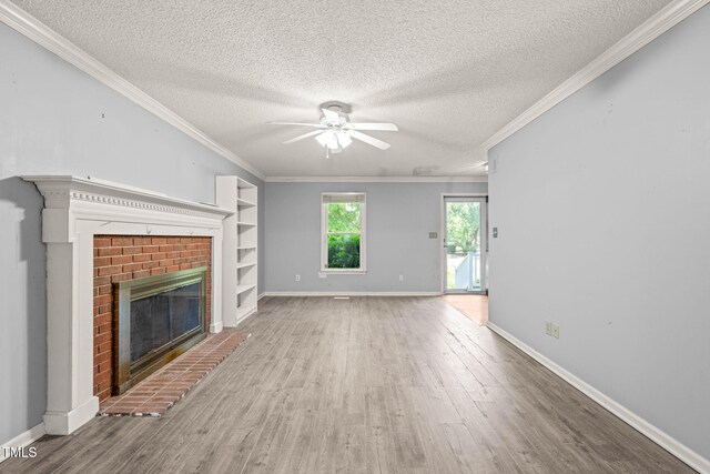 3 Cobble Glen Ct, Durham, NC 27713 - unfurnished living room with a ceiling fan, wood finished floors, a brick fireplace, a textured ceiling, and crown molding