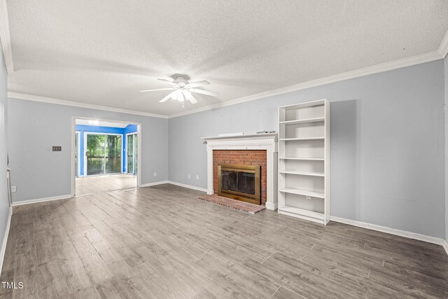 3 Cobble Glen Ct, Durham, NC 27713 - unfurnished living room with ceiling fan, a textured ceiling, wood finished floors, a brick fireplace, and ornamental molding
