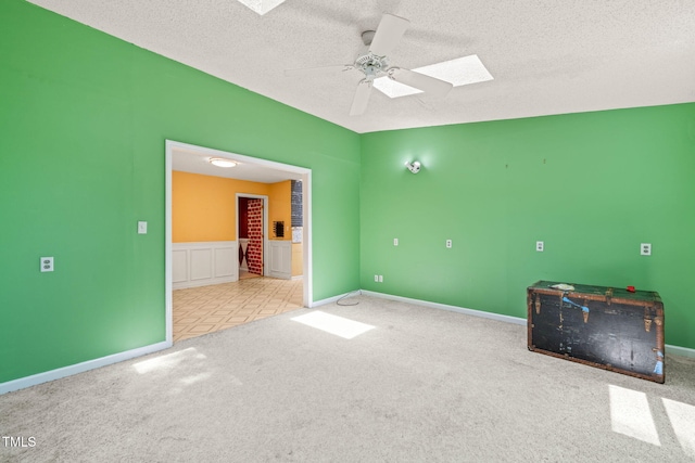 3 Cobble Glen Ct, Durham, NC 27713 - unfurnished room with carpet flooring, a skylight, a ceiling fan, a textured ceiling, and baseboards