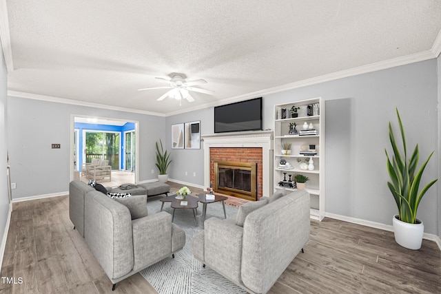 3 Cobble Glen Ct, Durham, NC 27713 - living area with wood finished floors, a textured ceiling, a ceiling fan, a brick fireplace, and crown molding