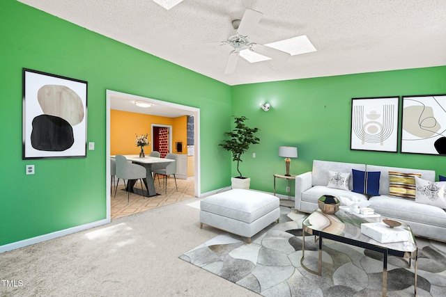 3 Cobble Glen Ct, Durham, NC 27713 - carpeted living room with a skylight, ceiling fan, baseboards, and a textured ceiling