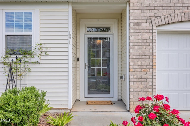 view of exterior entry with brick siding