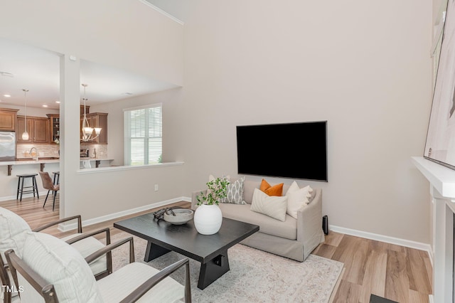 living area with light wood finished floors, baseboards, a chandelier, and recessed lighting