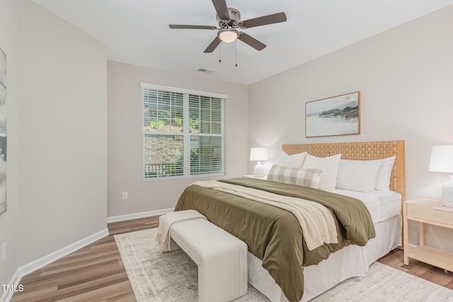 bedroom with light wood finished floors, baseboards, and ceiling fan