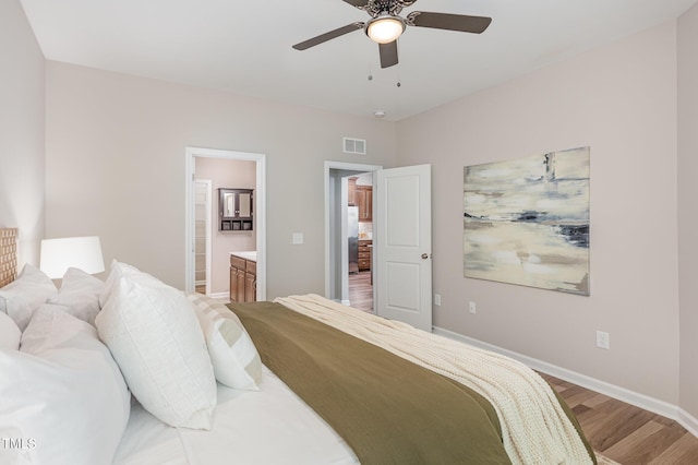 bedroom featuring light wood-style floors, baseboards, ensuite bathroom, and a ceiling fan