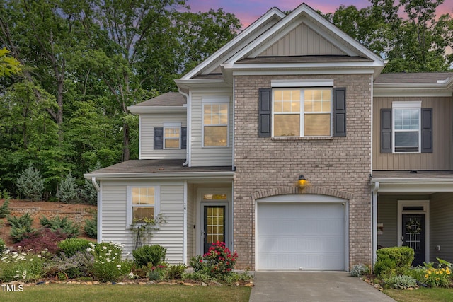 view of front of home featuring a garage, driveway, board and batten siding, and a shingled roof