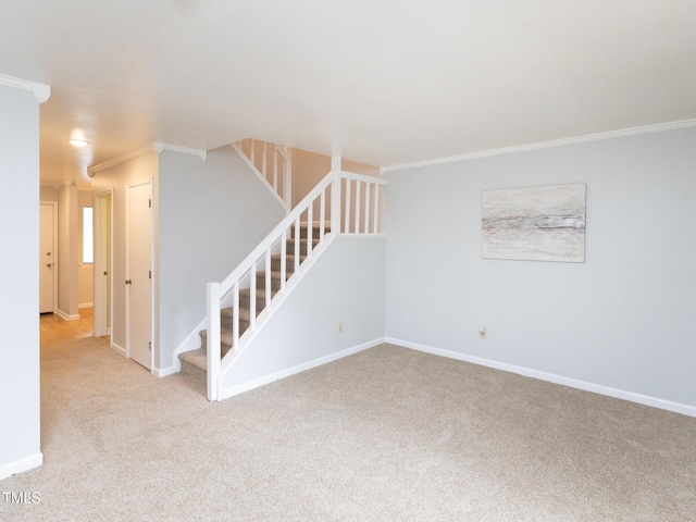 spare room with crown molding, stairs, carpet flooring, and baseboards
