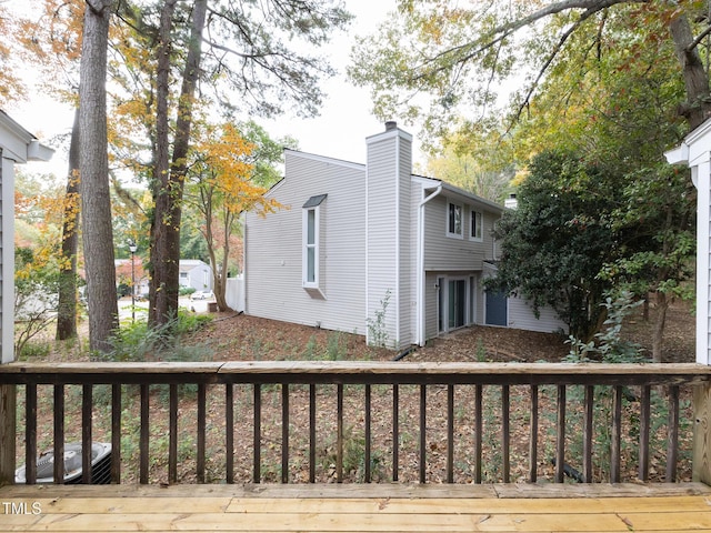 view of home's exterior featuring a chimney and a wooden deck