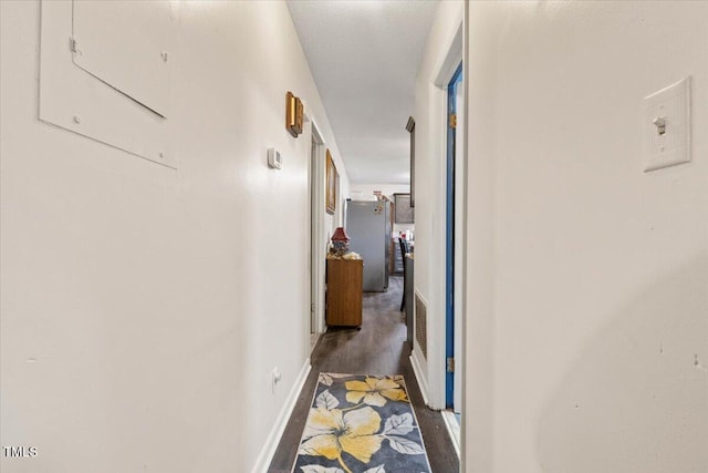corridor featuring wood finished floors and baseboards