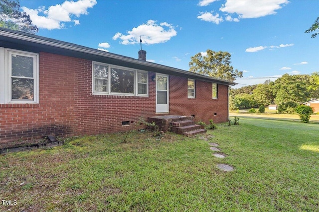 view of front of house featuring a front yard, crawl space, and brick siding
