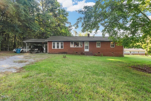 rear view of property with crawl space, brick siding, a lawn, an attached carport, and driveway