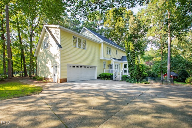 6201 King Croydon Ct, Raleigh, NC 27603 - traditional home with an attached garage, driveway, and view of wooded area