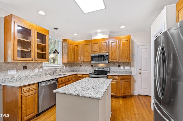 6201 King Croydon Ct, Raleigh, NC 27603 - kitchen with appliances with stainless steel finishes, ornamental molding, brown cabinetry, light stone counters, and hanging light fixtures