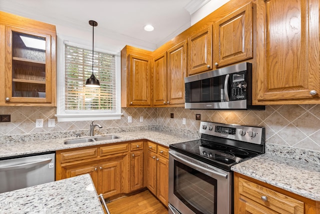 6201 King Croydon Ct, Raleigh, NC 27603 - kitchen featuring appliances with stainless steel finishes, ornamental molding, hanging light fixtures, light stone countertops, and brown cabinets