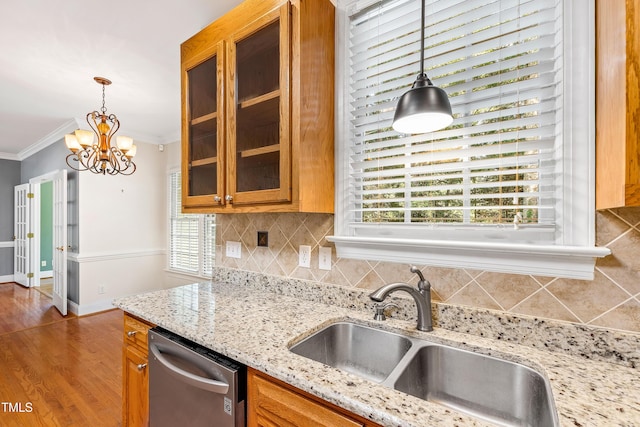 6201 King Croydon Ct, Raleigh, NC 27603 - kitchen featuring dishwasher, brown cabinetry, a chandelier, glass insert cabinets, and ornamental molding