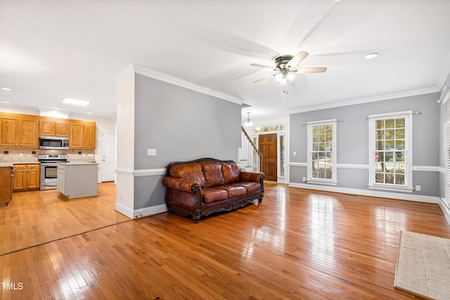 6201 King Croydon Ct, Raleigh, NC 27603 - living area with light wood finished floors, stairs, crown molding, and ceiling fan