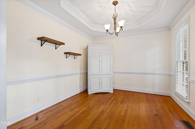 6201 King Croydon Ct, Raleigh, NC 27603 - unfurnished room featuring hardwood / wood-style floors, a chandelier, a tray ceiling, and ornamental molding