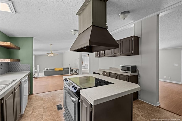 kitchen with stainless steel appliances, open shelves, a textured ceiling, light countertops, and ceiling fan
