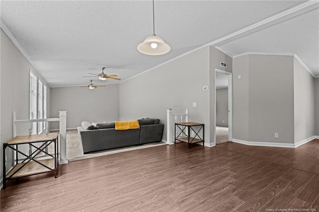 living room with ornamental molding, a textured ceiling, a ceiling fan, wood finished floors, and baseboards
