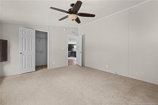 unfurnished bedroom featuring carpet flooring, ceiling fan, a textured ceiling, and crown molding