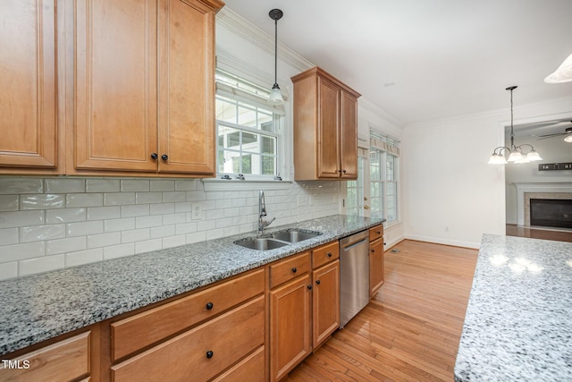 kitchen with dishwasher, a sink, light wood-type flooring, baseboards, and crown molding