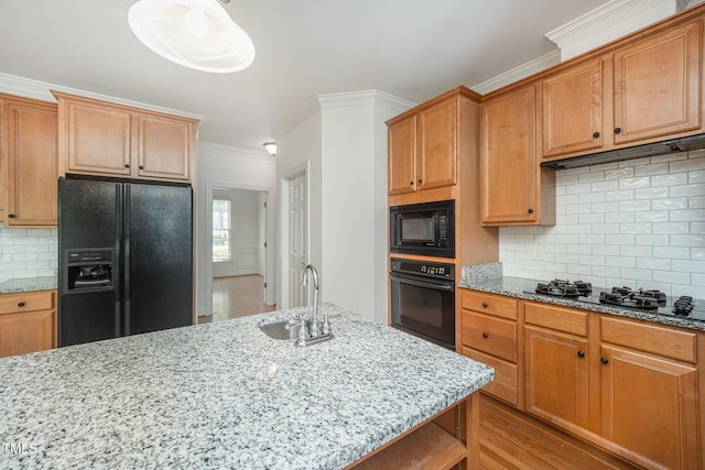 kitchen with black appliances, ornamental molding, a sink, light stone countertops, and tasteful backsplash