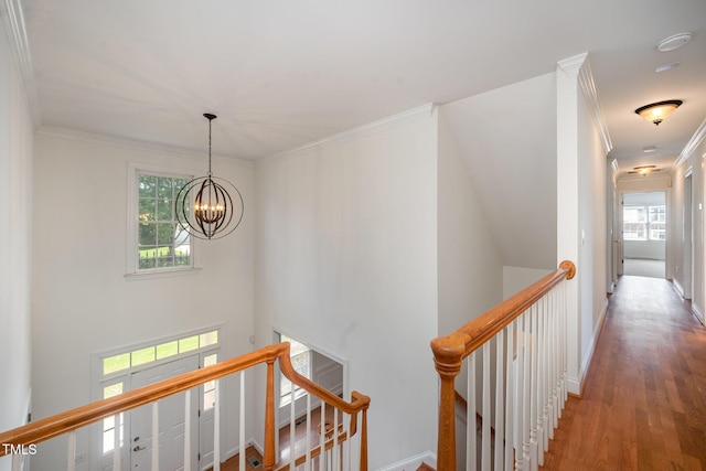 hall featuring an upstairs landing, crown molding, a chandelier, wood finished floors, and baseboards