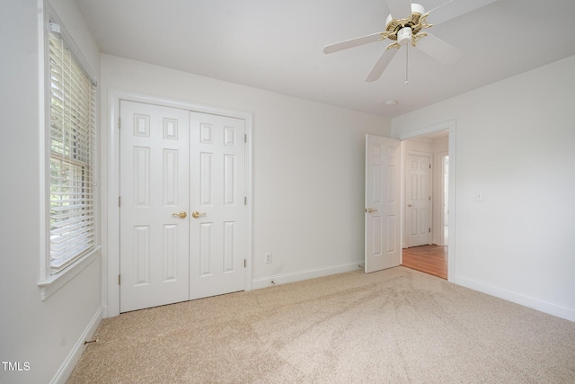 unfurnished bedroom featuring carpet floors, baseboards, a closet, and ceiling fan