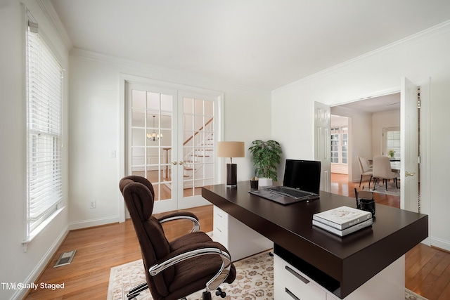office space featuring light wood finished floors, french doors, crown molding, and baseboards
