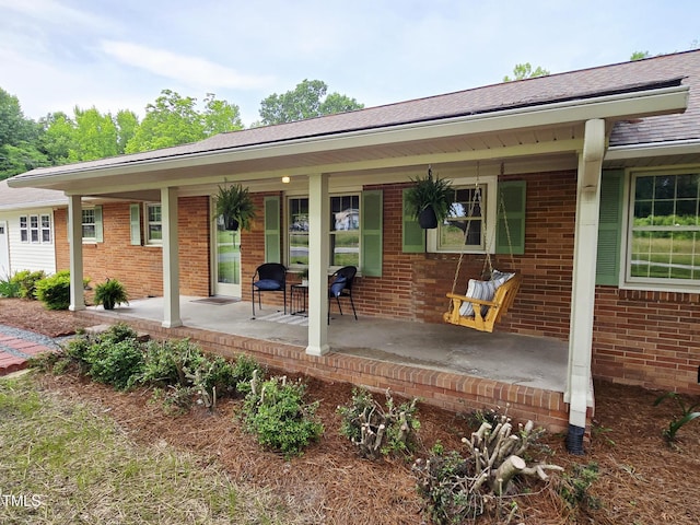 3669 W Greensboro Chapel Hill Rd, Liberty, NC 27298 - view of front of house with covered porch, brick siding, and roof with shingles