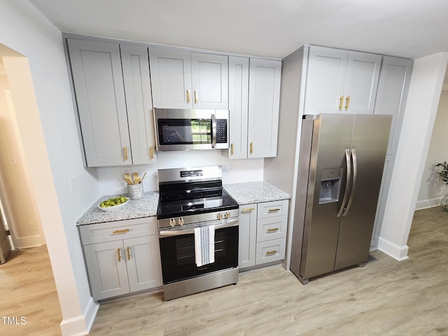 3669 W Greensboro Chapel Hill Rd, Liberty, NC 27298 - kitchen with appliances with stainless steel finishes, gray cabinets, and light wood-style floors