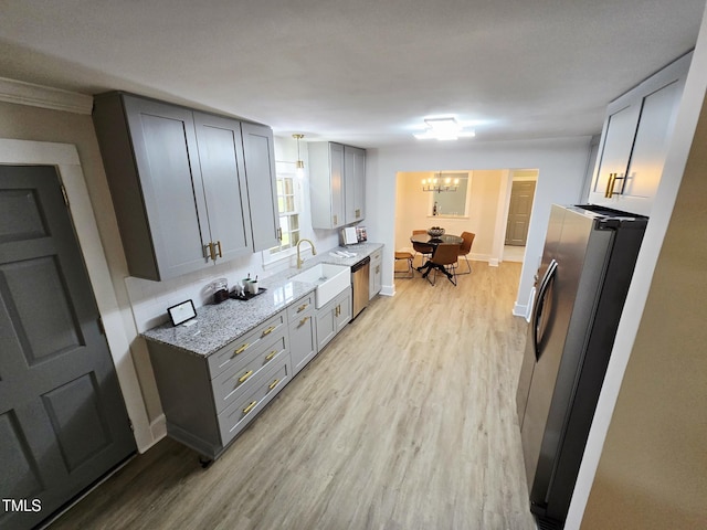 3669 W Greensboro Chapel Hill Rd, Liberty, NC 27298 - kitchen with appliances with stainless steel finishes, a sink, light wood-style floors, a chandelier, and light stone countertops