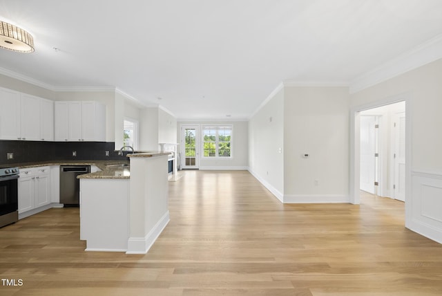 340 Allister Dr Unit 301, Raleigh, NC 27609 - kitchen featuring appliances with stainless steel finishes, open floor plan, a peninsula, ornamental molding, and white cabinetry
