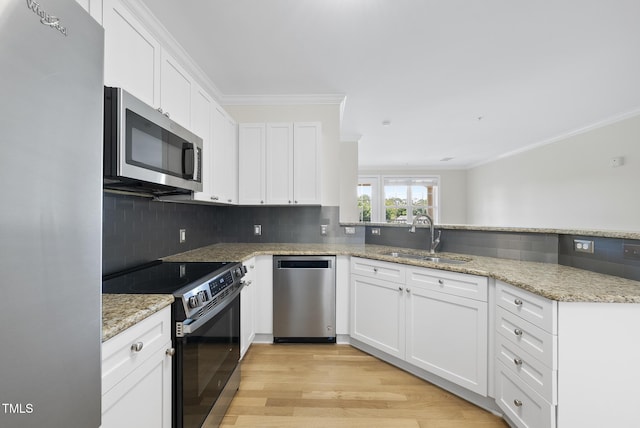 340 Allister Dr Unit 301, Raleigh, NC 27609 - kitchen featuring appliances with stainless steel finishes, a sink, crown molding, decorative backsplash, and white cabinets