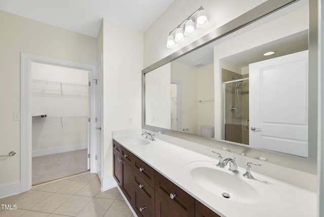 340 Allister Dr Unit 301, Raleigh, NC 27609 - full bath featuring a shower stall, double vanity, tile patterned flooring, a walk in closet, and baseboards