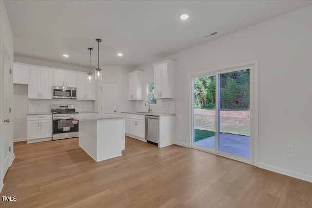114 Hays St, Oxford, NC 27565 - kitchen with stainless steel appliances, decorative backsplash, white cabinets, light wood-style floors, and recessed lighting