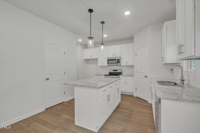 114 Hays St, Oxford, NC 27565 - kitchen with appliances with stainless steel finishes, decorative backsplash, white cabinets, light wood finished floors, and decorative light fixtures
