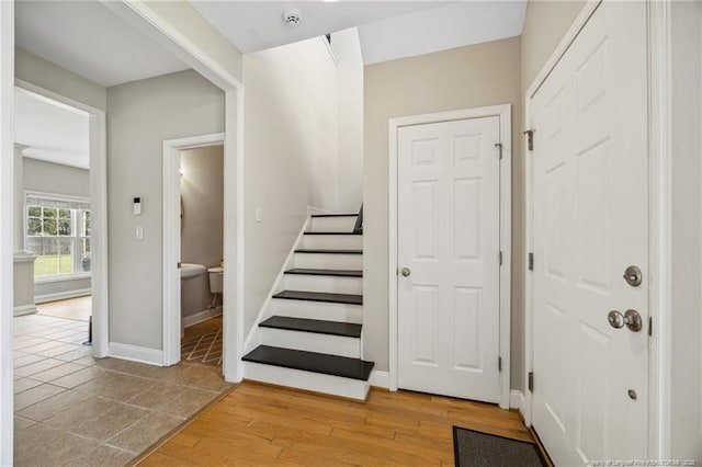 stairway featuring wood finished floors and baseboards