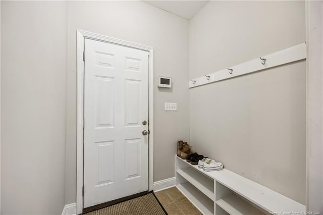mudroom with baseboards and dark tile patterned flooring