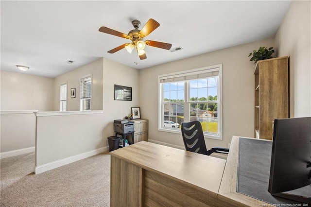 office with baseboards, healthy amount of natural light, a ceiling fan, and carpet floors