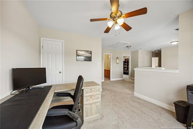 home office featuring attic access, ceiling fan, light carpet, and baseboards