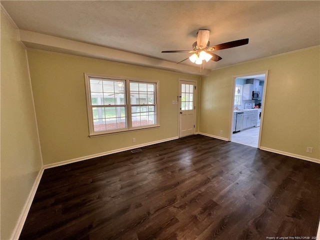 empty room with dark wood-style flooring, a ceiling fan, baseboards, and a sink