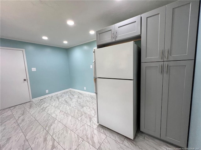 kitchen with freestanding refrigerator, gray cabinetry, recessed lighting, baseboards, and light marble finish flooring
