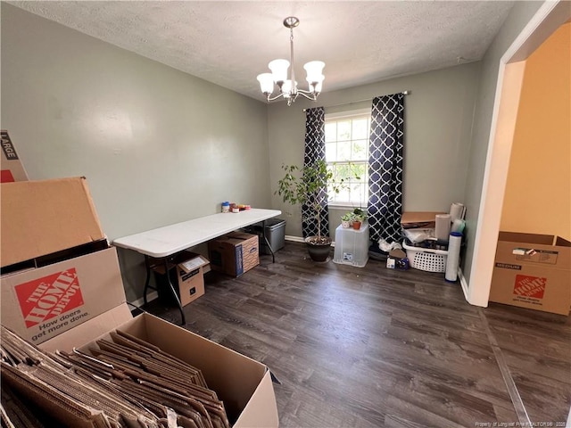 misc room with a chandelier, a textured ceiling, dark wood finished floors, and baseboards