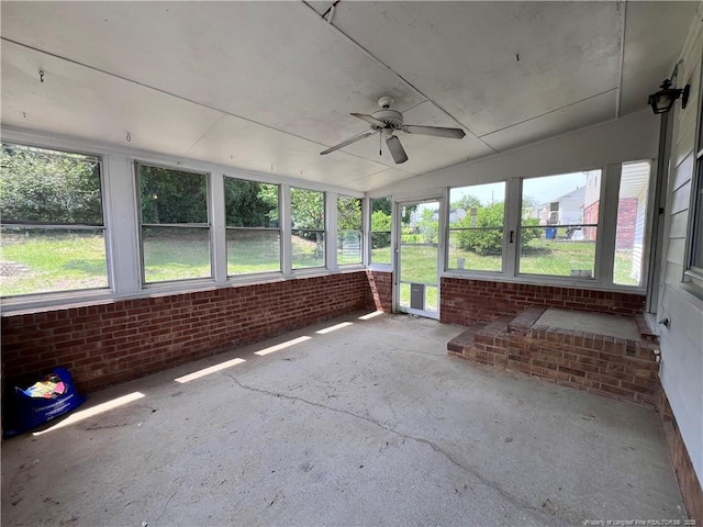 unfurnished sunroom featuring a ceiling fan, vaulted ceiling, and healthy amount of natural light