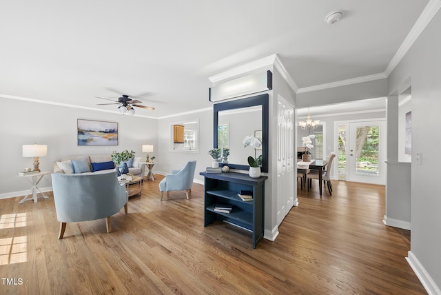 1201 Pond St, Cary, NC 27511 - living area featuring wood finished floors, a chandelier, ornamental molding, and a ceiling fan