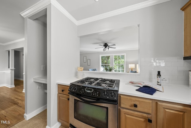 1201 Pond St, Cary, NC 27511 - kitchen featuring stainless steel gas range oven, ornamental molding, backsplash, a ceiling fan, and light countertops