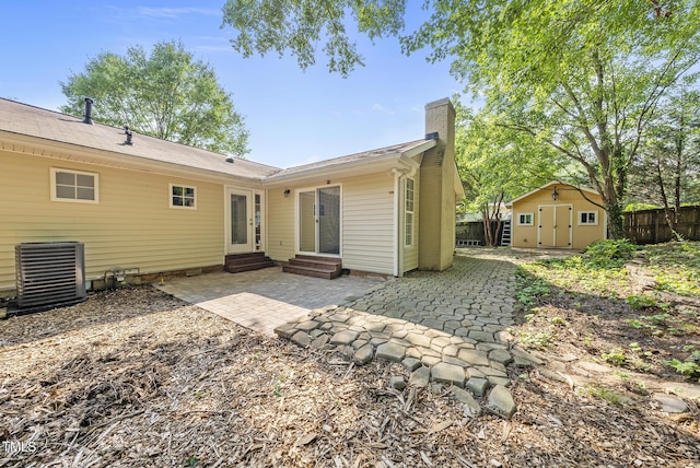 1201 Pond St, Cary, NC 27511 - rear view of house with entry steps, a chimney, a patio, and a storage shed